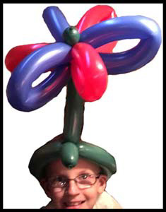 Balloon maker Daisy Doodle twists  balloon party hat for child in Jersey City NJ