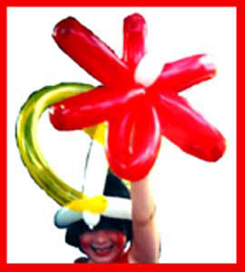 Balloon twister Daisy Doodle delights birthday girl with balloon flower hat in Manhattan NYC