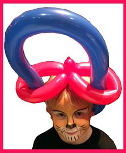 Balloon twister Daisy Doodle makes balloon hat and lion face painting for birthday child in Brooklyn NYC
