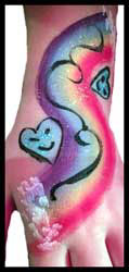 Child gets rainbow hearts body painting on hand and arms in Brooklyn NY