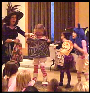 Children volunteers help decorate in Daisy Doodle's magic show for company halloween party in Manhattan NY