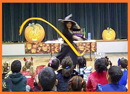 Daisy Doodle dances to music with props at beginning of kids halloween party magic show