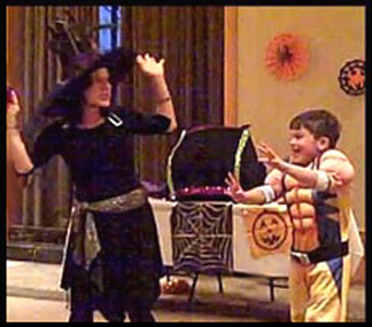 Boy dances the monster mash with Halloween party entertainer Daisy Doodle during the magic show