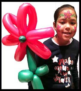 Girl poses with a balloon twisted Christmas poinsetta flower in Bronx NY