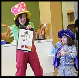 Girl dressed in painters outfit helps magician Daisy Doodle paint a snowman at Hanukkah holiday party in Brooklyn NYC