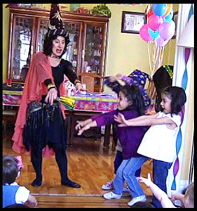 Children help Daisy Doodle at wizard magic show by waving their fingers and saying magic word in Westchester NY