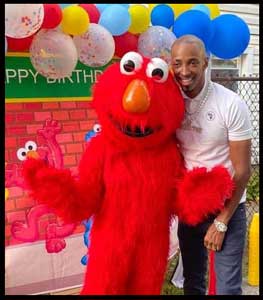 Dad poses with Elmo character at childrens birthday party in Brooklyn NYC