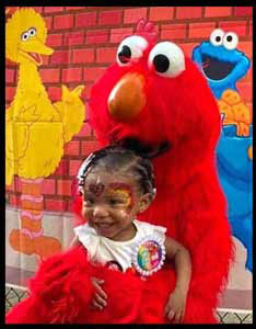 Elmo hugs little girl at kids birthday party entertainment in New York City